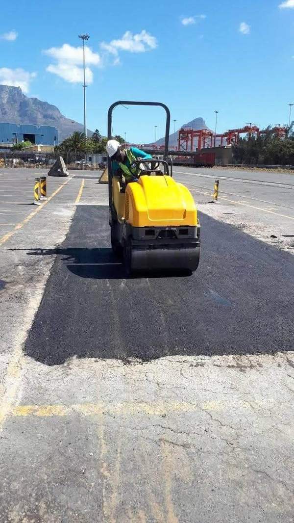 Roller compacting an asphalt repair with Table Mountain behind