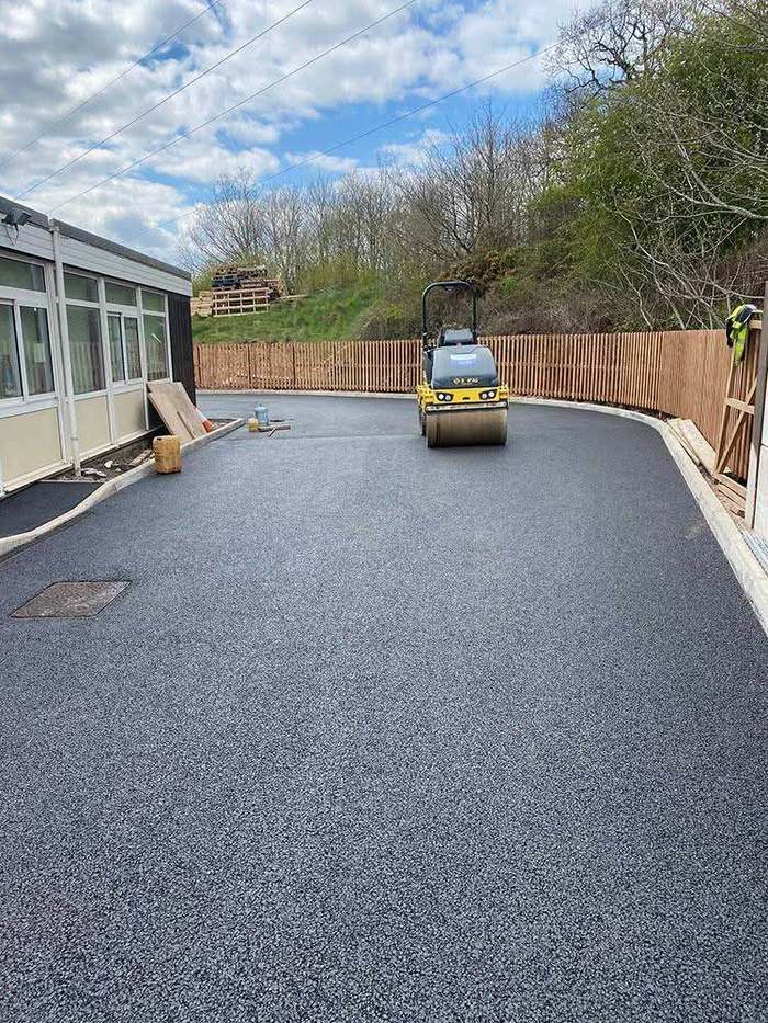 Roller compacting freshly laid asphalt