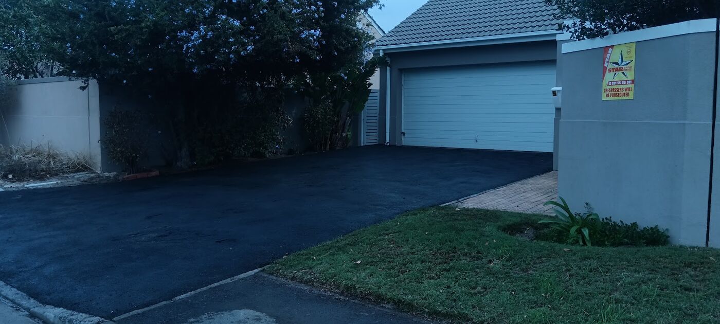 Freshly completed tar driveway at a home garage