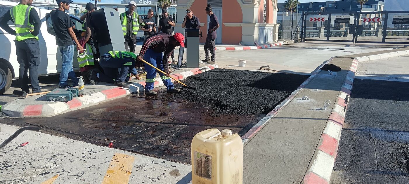 Team raking hot asphalt at a gatehouse