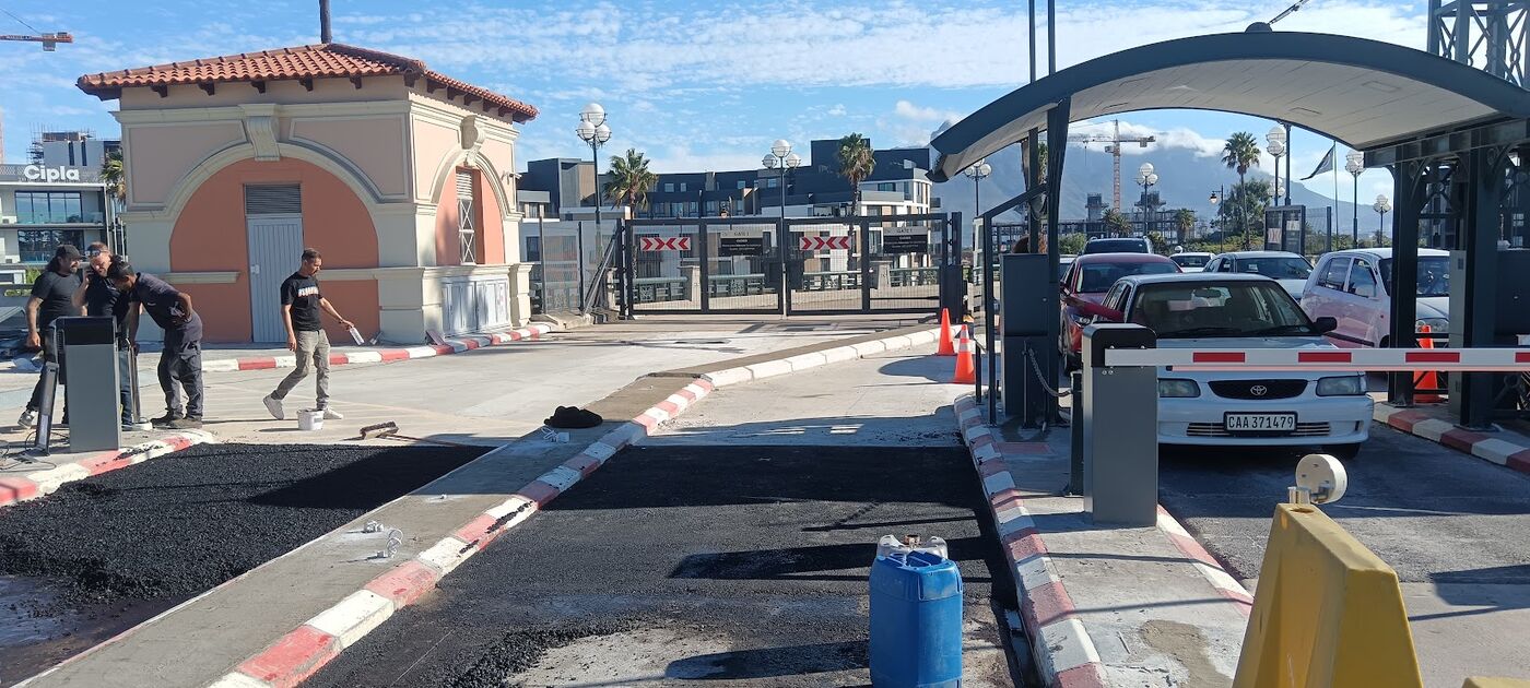 Fresh asphalt lanes at a gatehouse with boom gates