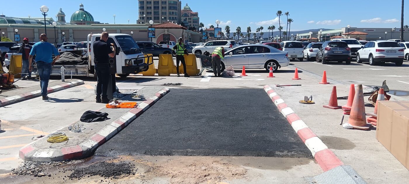 Completed asphalt traffic island with red and white kerbs