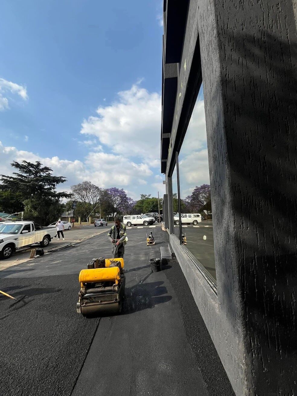 Roller compacting fresh asphalt on a suburban street
